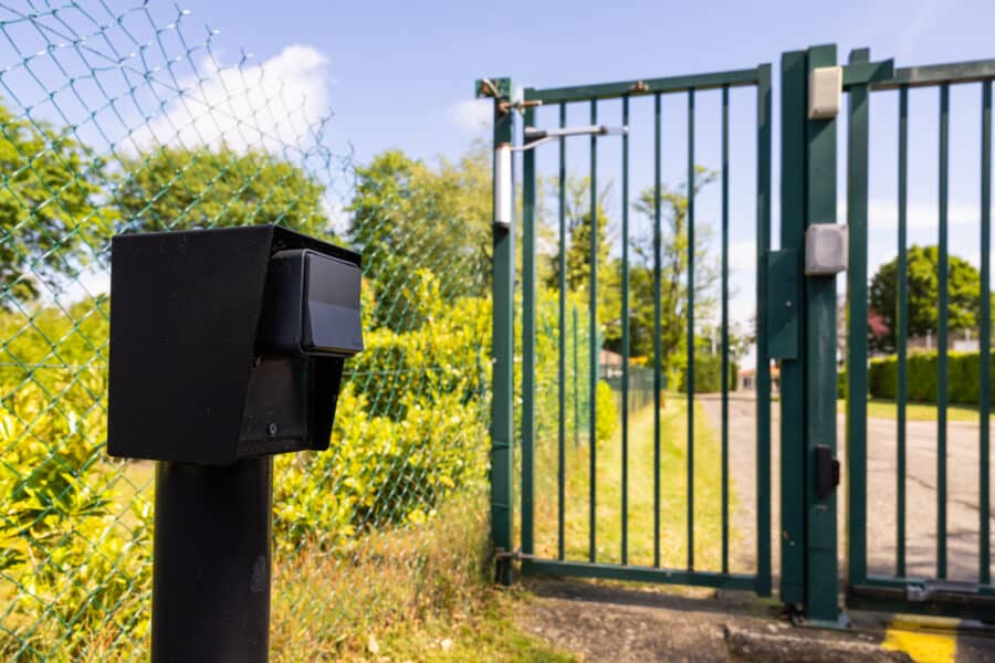 Portail vert et interphone de sécurité extérieur.