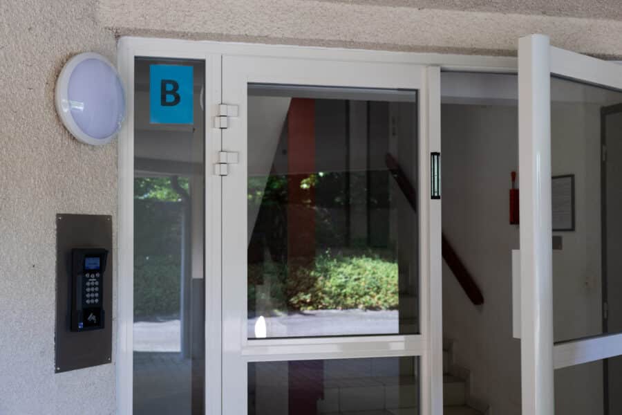 Entrée d'immeuble avec interphone et porte ouverte