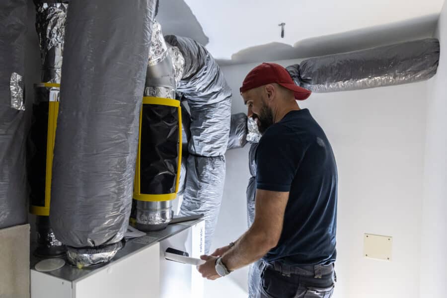 Homme inspecte système de ventilation intérieure.